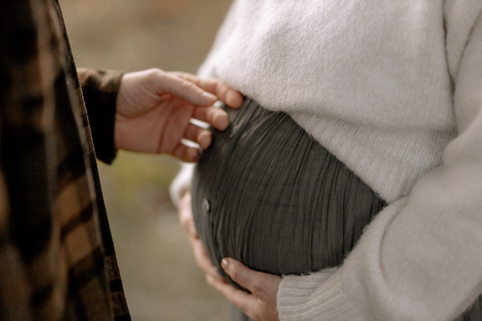 Schwangere Frau formt mit den Händen auf dem Bauch